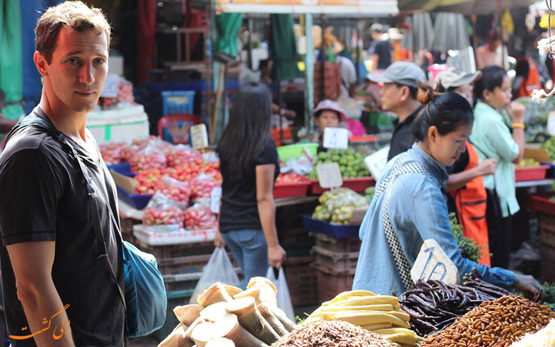 یک توریست در حال خرید در بازارهای تایلند
